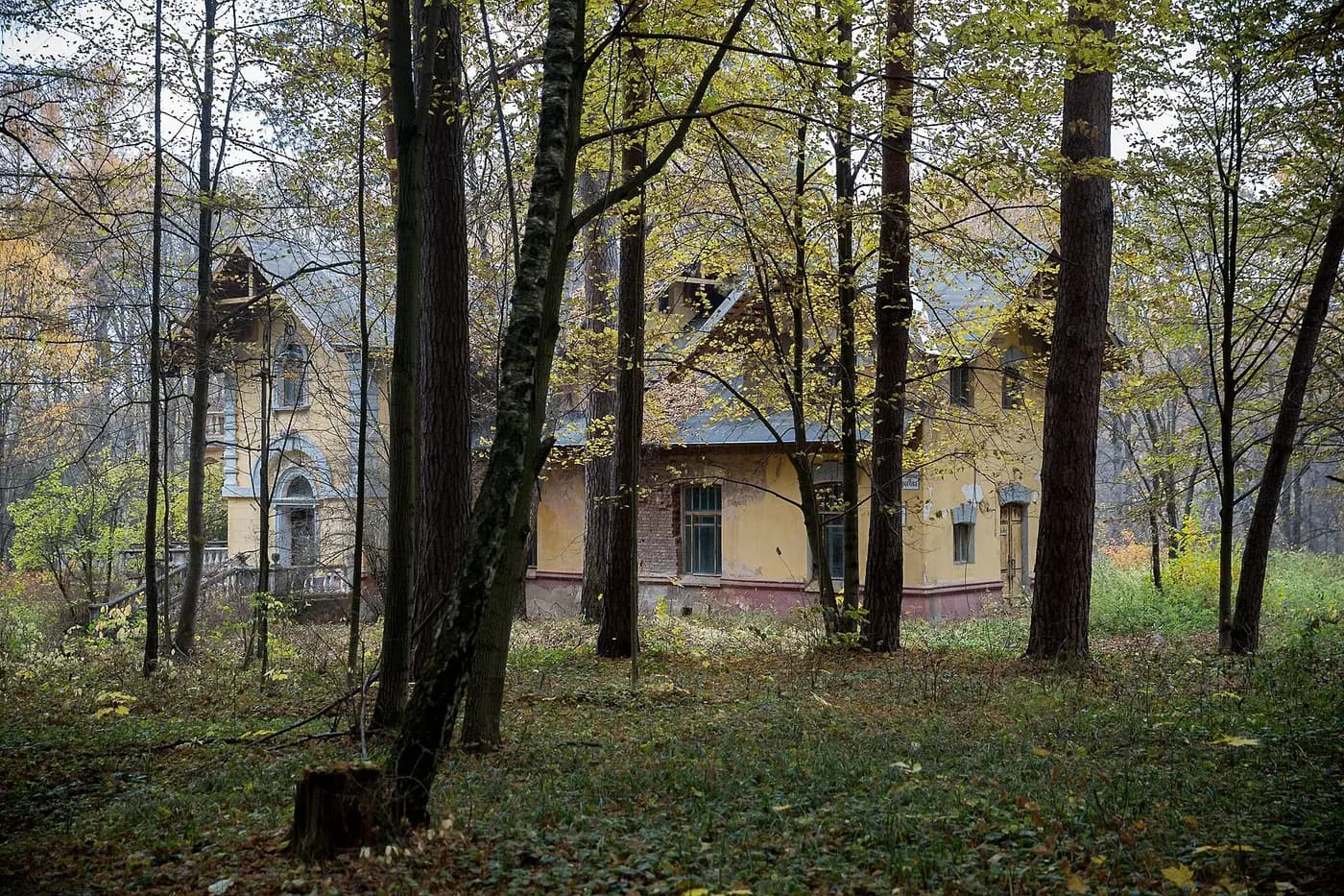Усадебный дом среди деревьев осенью
