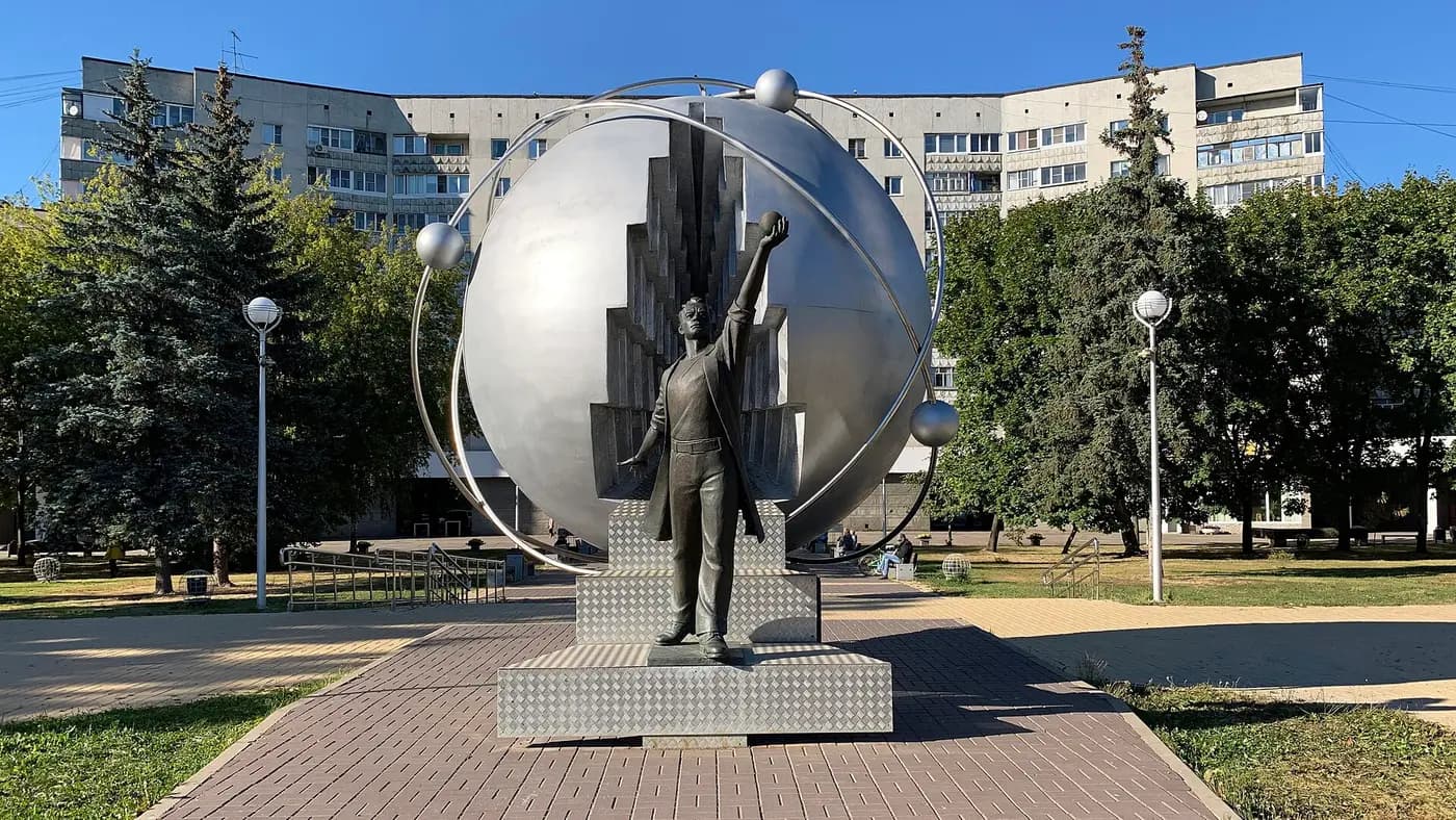 Бронзовая фигура на фоне серебристой сферы